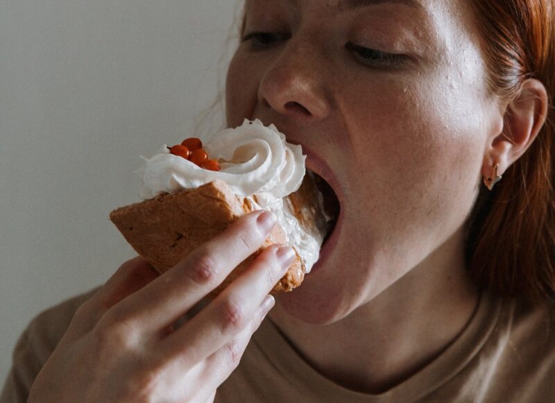 mulher comendo uma fatia de bolo