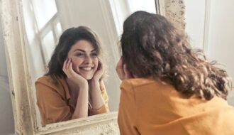 mulher morena se olhando no espelho