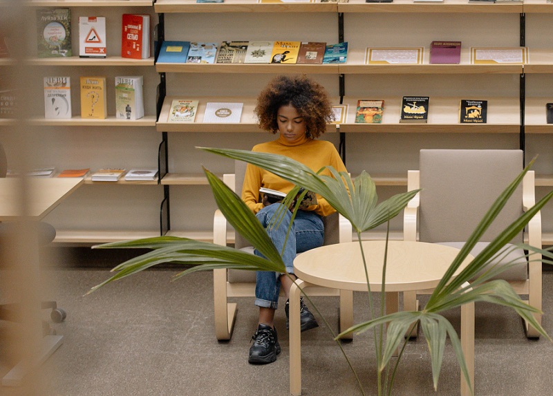 mulher lendo livro em uma biblioteca