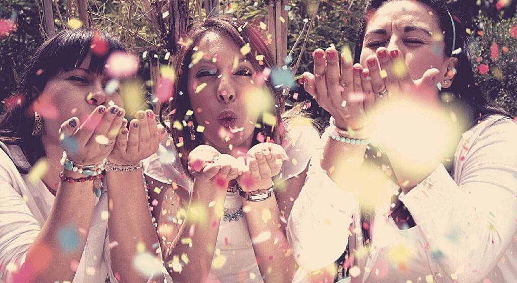 três mulheres sobrando papel picado