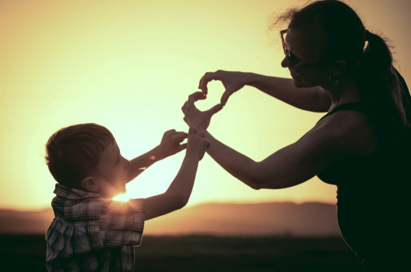 maternidade mãe e filho fazendo coração com as mãos